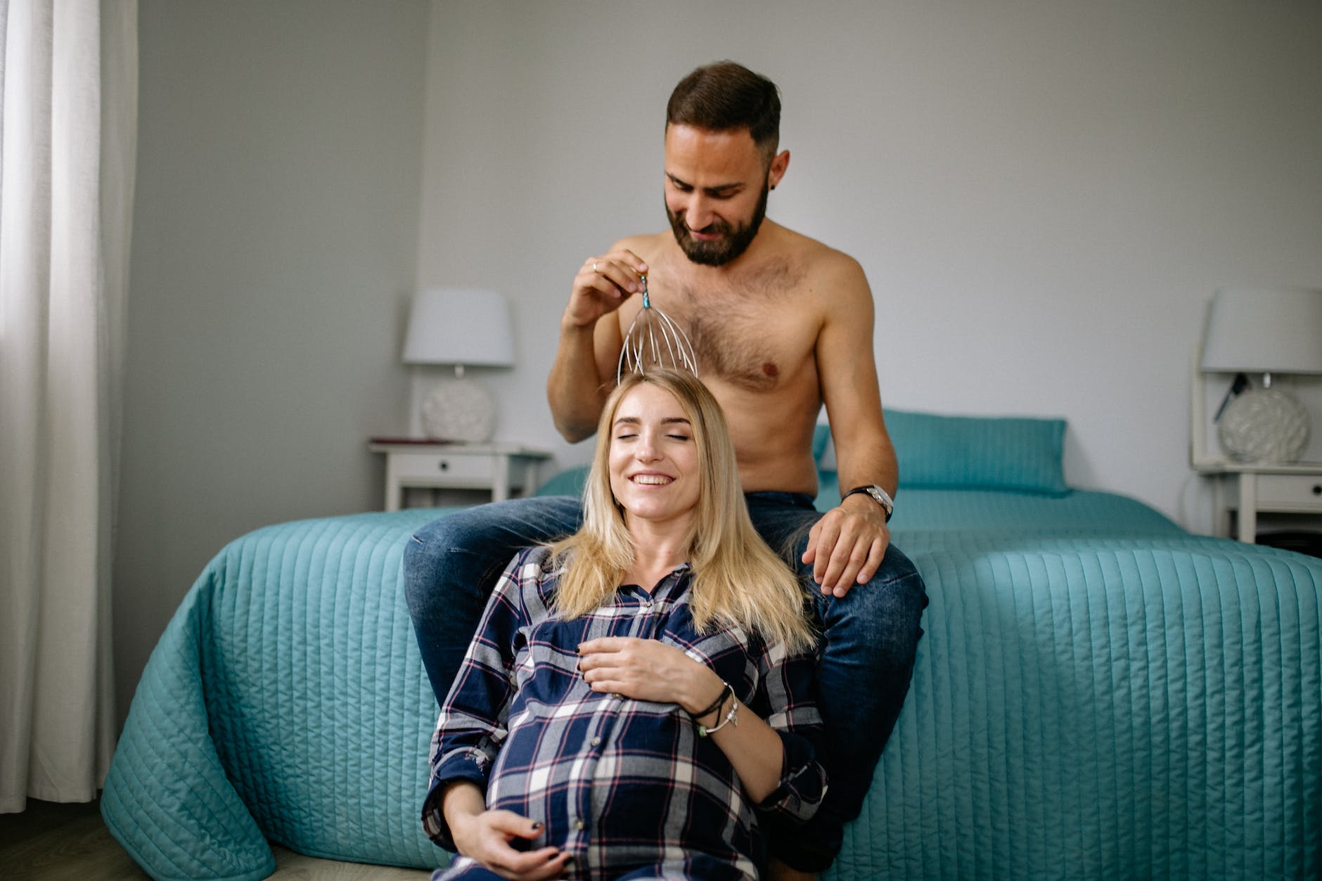 man massaging his pregnant partner head and smiling